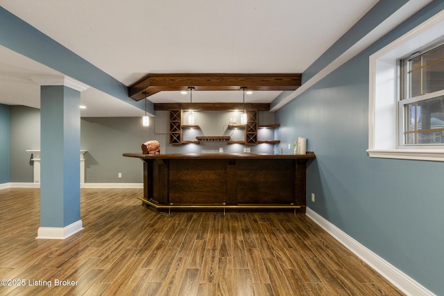 bar featuring baseboards, dark wood-style flooring, and pendant lighting