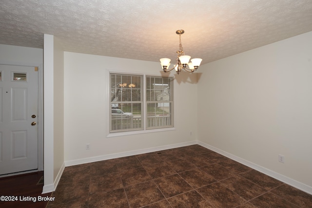 unfurnished dining area with a textured ceiling and an inviting chandelier