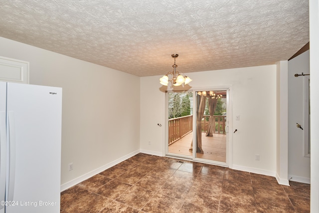 unfurnished dining area with a textured ceiling and a chandelier