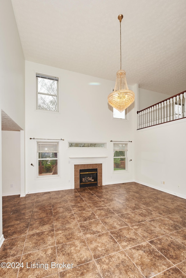 unfurnished living room featuring a high ceiling and a fireplace