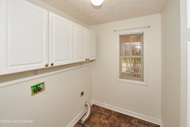 laundry area with cabinets, washer hookup, hookup for an electric dryer, and a textured ceiling