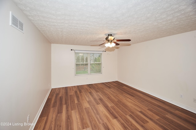 spare room featuring ceiling fan, dark hardwood / wood-style floors, and a textured ceiling