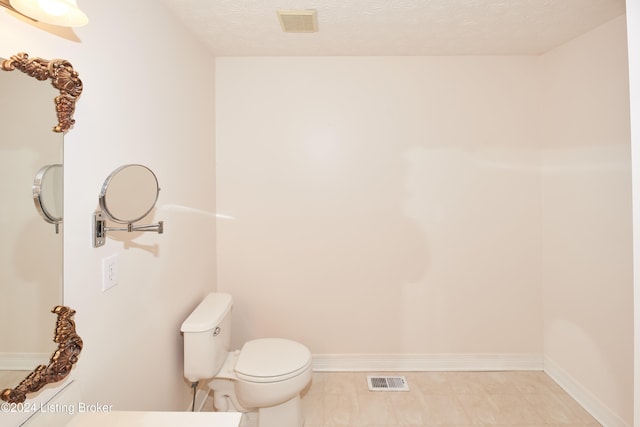 bathroom featuring toilet and a textured ceiling