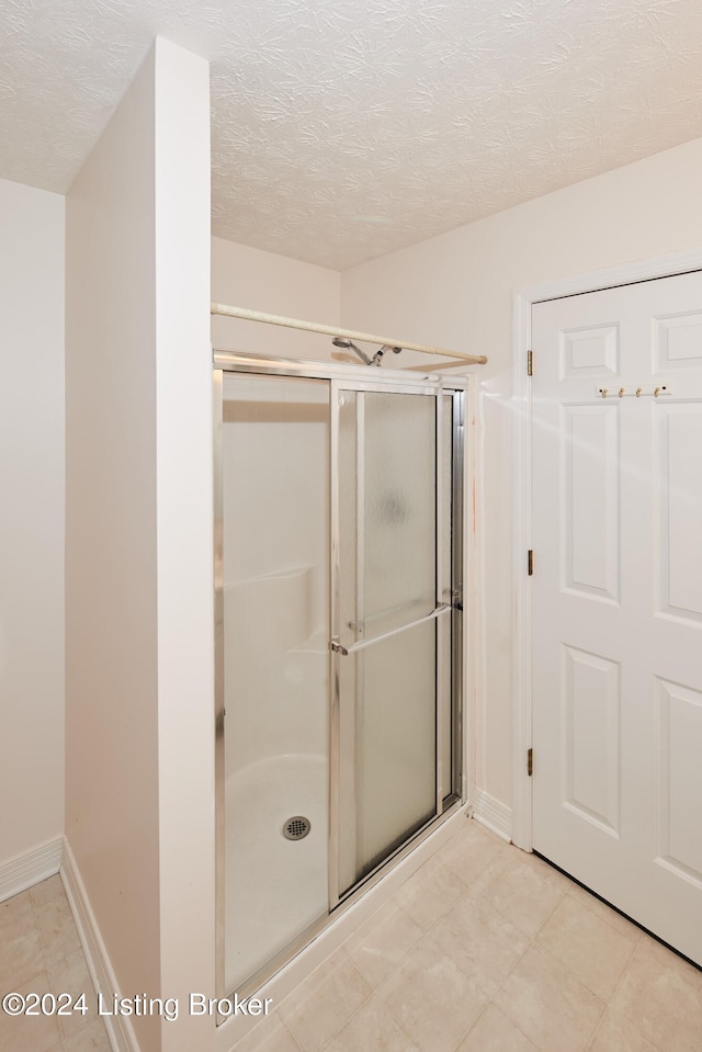 bathroom with a textured ceiling and walk in shower