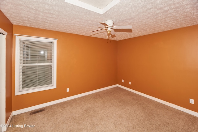 unfurnished room with ceiling fan, carpet flooring, and a textured ceiling