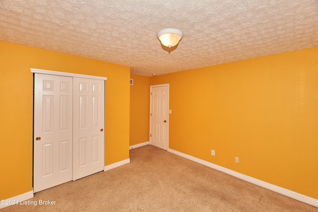 unfurnished bedroom with a closet, a textured ceiling, and carpet flooring