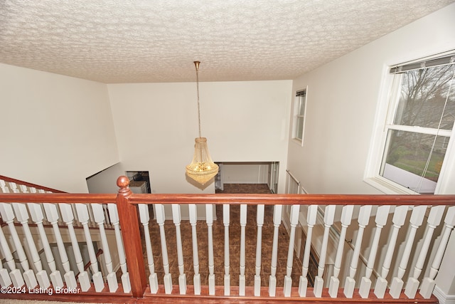 stairway featuring a textured ceiling