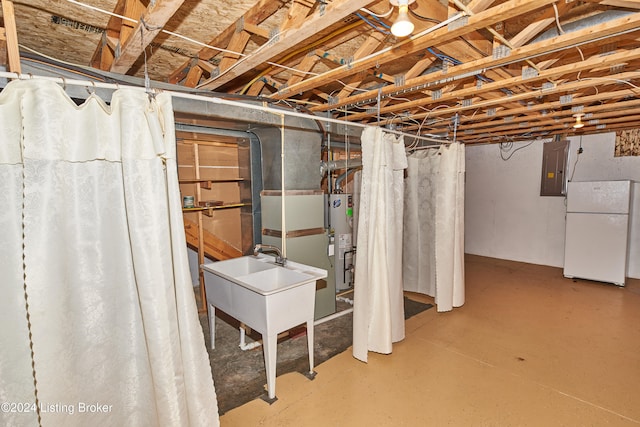 basement featuring water heater, white fridge, and electric panel