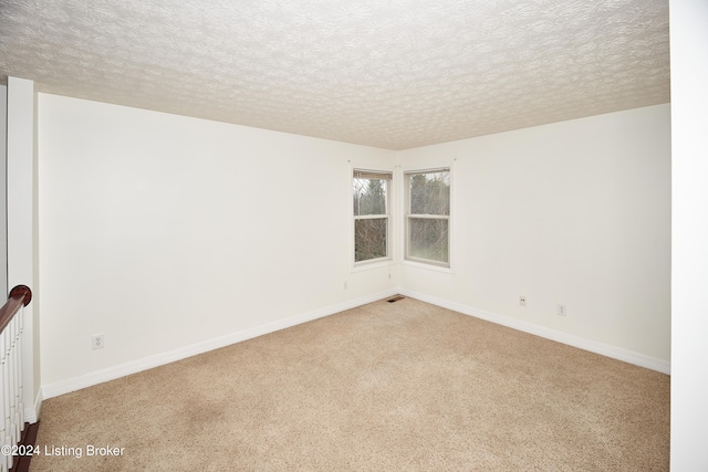 carpeted empty room featuring a textured ceiling