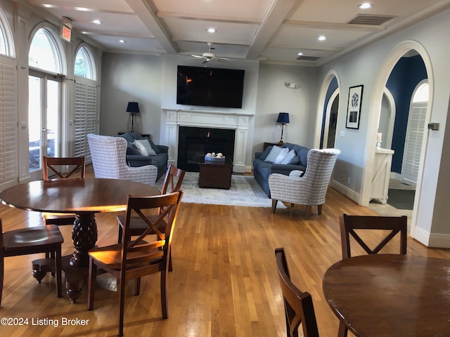 dining room featuring coffered ceiling, beam ceiling, light hardwood / wood-style flooring, and ceiling fan