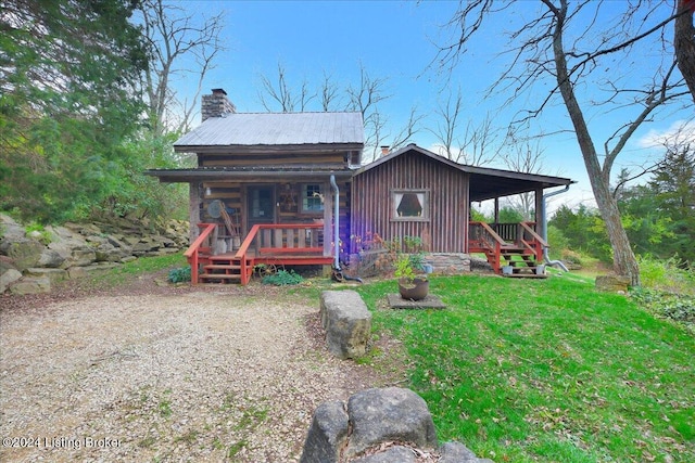 rear view of house with a yard and a porch