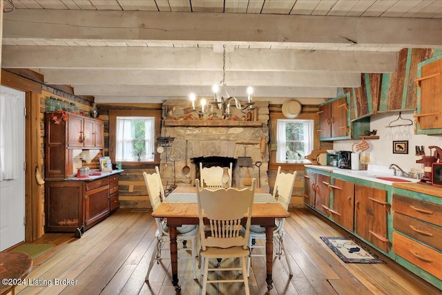 dining space featuring beam ceiling, light hardwood / wood-style flooring, and a notable chandelier