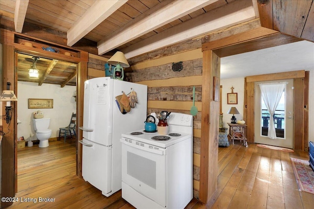 kitchen with hardwood / wood-style floors, white appliances, and beamed ceiling