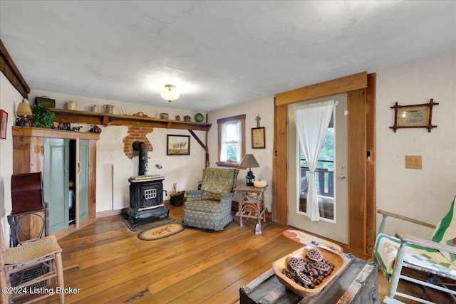 sitting room with wood-type flooring and a wood stove