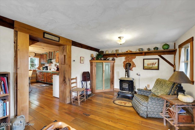 living area featuring a wood stove and wood-type flooring