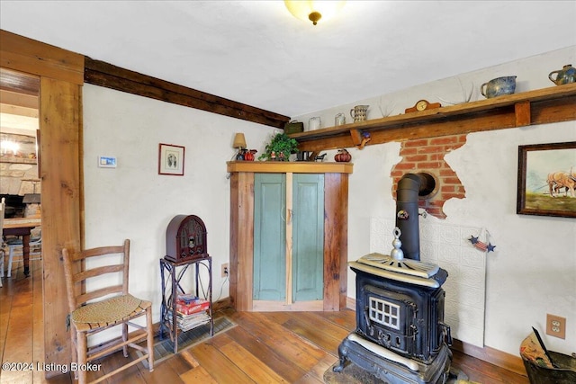 living room with a wood stove and hardwood / wood-style flooring