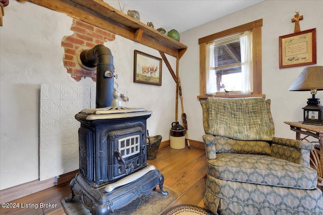 sitting room featuring dark hardwood / wood-style floors and a wood stove