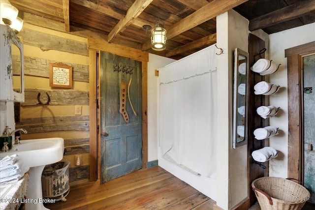 bathroom with beam ceiling, hardwood / wood-style flooring, and wood ceiling