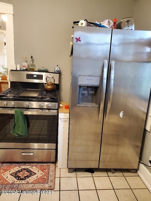 kitchen with light tile patterned flooring and appliances with stainless steel finishes