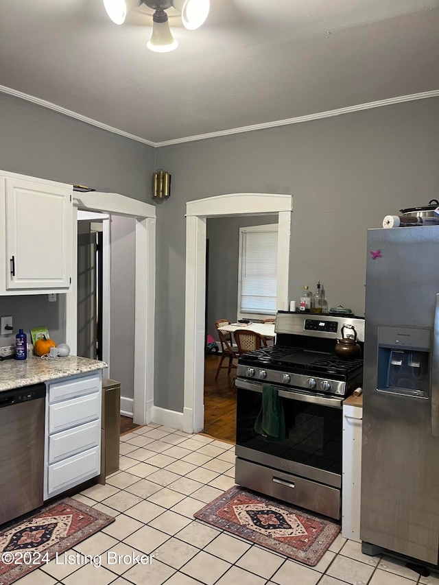 kitchen featuring crown molding, stainless steel appliances, white cabinets, and light tile patterned flooring