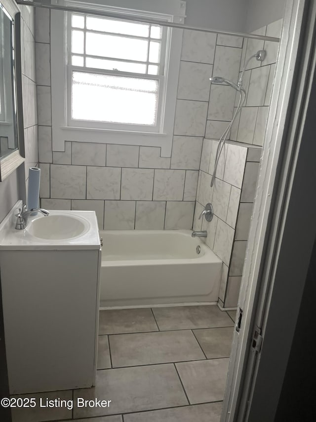 bathroom featuring vanity, tile patterned flooring, and tiled shower / bath