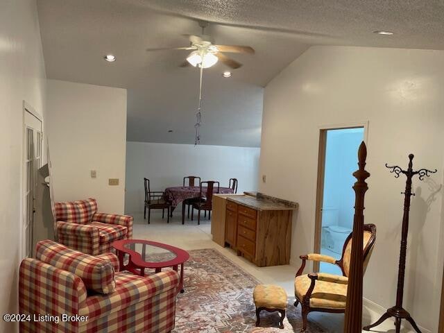 sitting room featuring ceiling fan, light colored carpet, a textured ceiling, and high vaulted ceiling