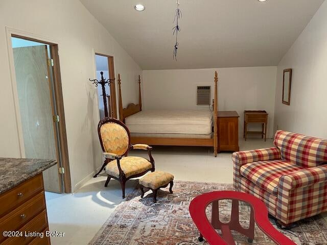 carpeted bedroom featuring a wall mounted AC and vaulted ceiling