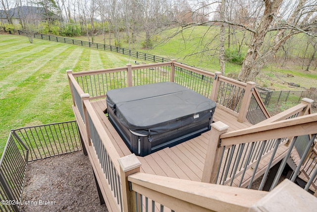 deck featuring a lawn, a rural view, and a hot tub