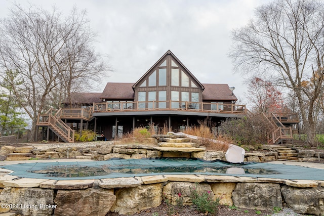 rear view of property with a pool side deck