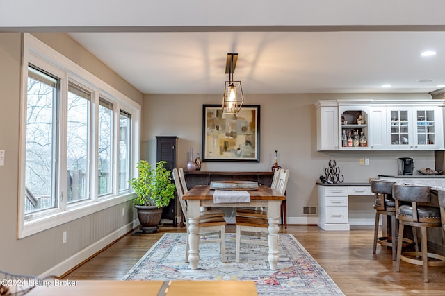 dining area featuring wood-type flooring and bar