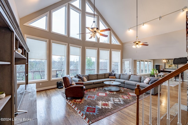 living room with rail lighting, hardwood / wood-style flooring, high vaulted ceiling, and ceiling fan