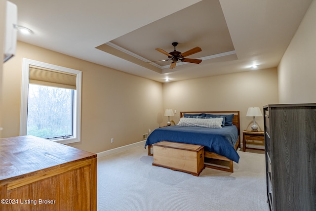 bedroom with a tray ceiling, ceiling fan, crown molding, and light colored carpet