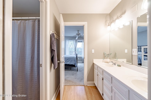 bathroom with wood-type flooring, vanity, and ceiling fan