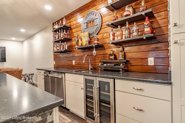 bar with wine cooler, wooden walls, sink, and dark hardwood / wood-style floors