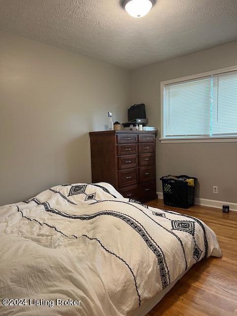 bedroom featuring light hardwood / wood-style flooring and a textured ceiling