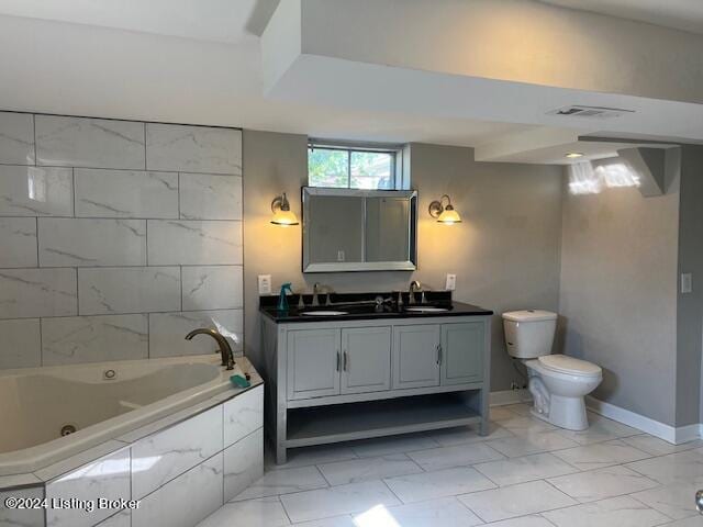 bathroom featuring vanity, toilet, and tiled tub