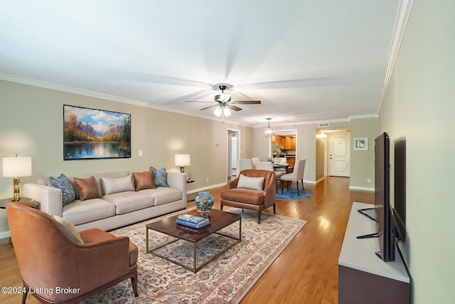 living room featuring crown molding, ceiling fan, and light hardwood / wood-style floors