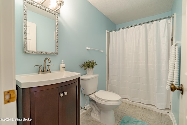 bathroom with tile patterned floors, vanity, a textured ceiling, and toilet