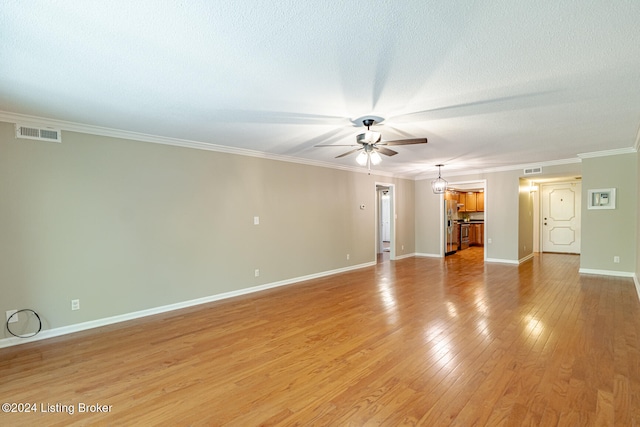 empty room featuring a textured ceiling, light hardwood / wood-style floors, ceiling fan, and crown molding