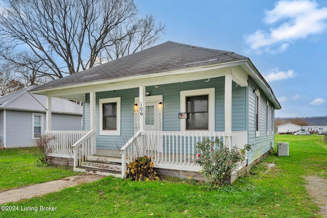 bungalow-style house featuring central air condition unit and a front lawn