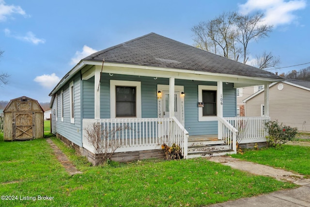 bungalow-style house featuring covered porch, a shed, and a front lawn