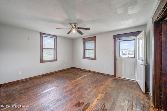 interior space featuring dark hardwood / wood-style floors, ceiling fan, and a textured ceiling