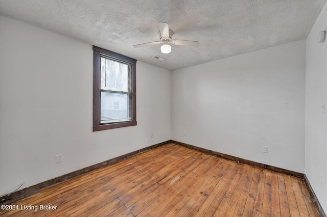 empty room with hardwood / wood-style floors, ceiling fan, and a textured ceiling