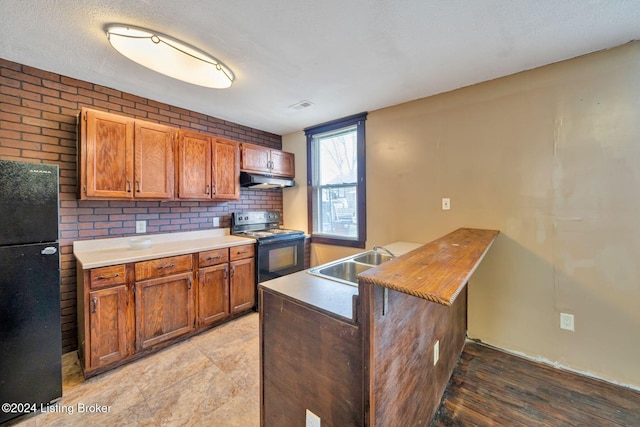 kitchen with black appliances, sink, a textured ceiling, light hardwood / wood-style floors, and kitchen peninsula