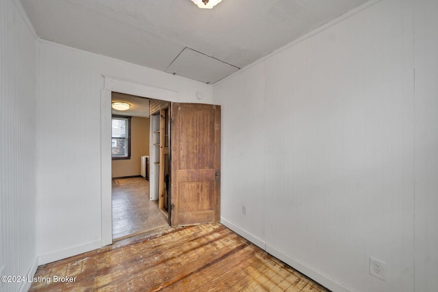 spare room with radiator heating unit and light hardwood / wood-style floors