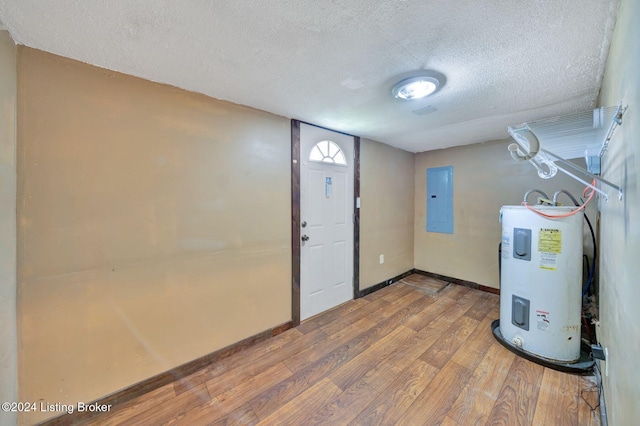 entrance foyer with electric panel, electric water heater, wood-type flooring, and a textured ceiling