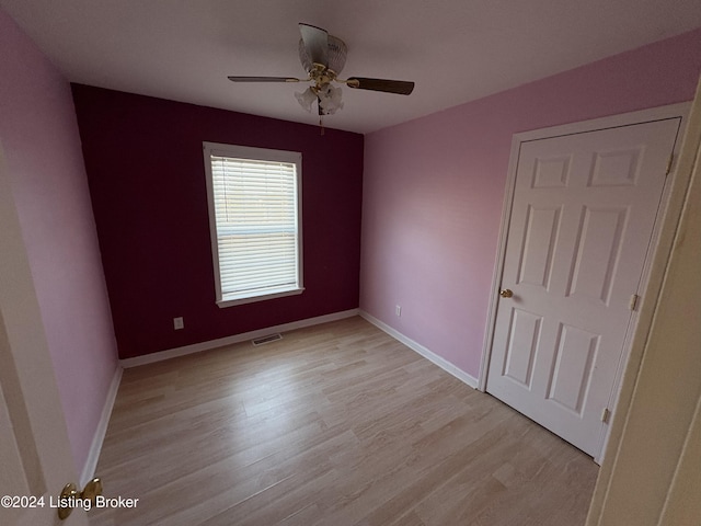 spare room with ceiling fan and light wood-type flooring