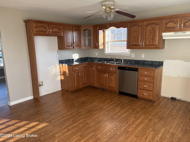 kitchen with dark hardwood / wood-style flooring, sink, stainless steel dishwasher, and a textured ceiling