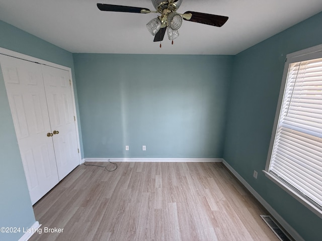 unfurnished bedroom featuring ceiling fan, light wood-type flooring, and a closet