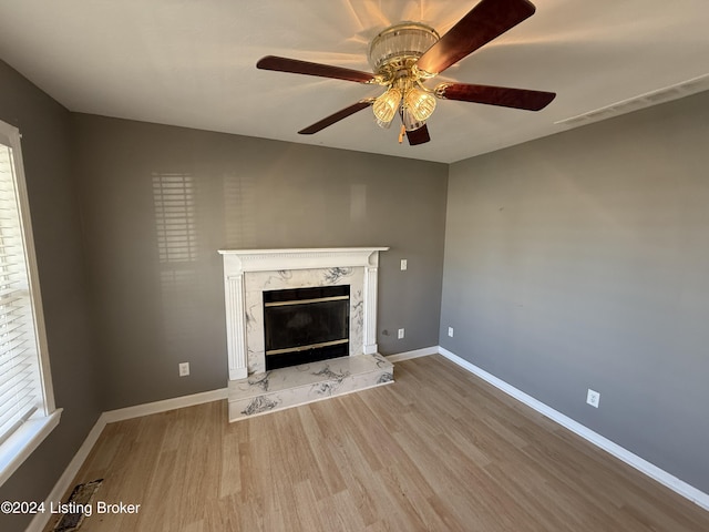 unfurnished living room with a fireplace, hardwood / wood-style flooring, and ceiling fan